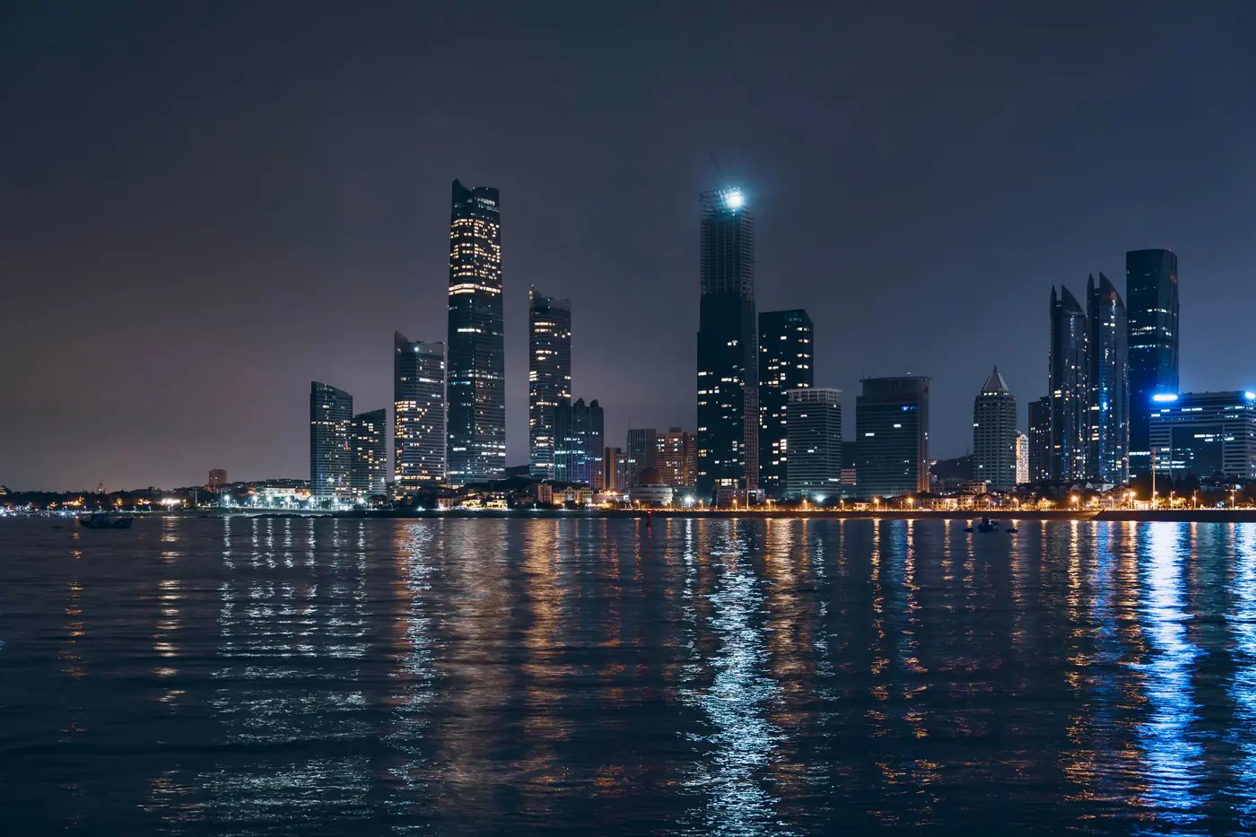 Abu Dhabi skyline reflected in the water at night — location photography
